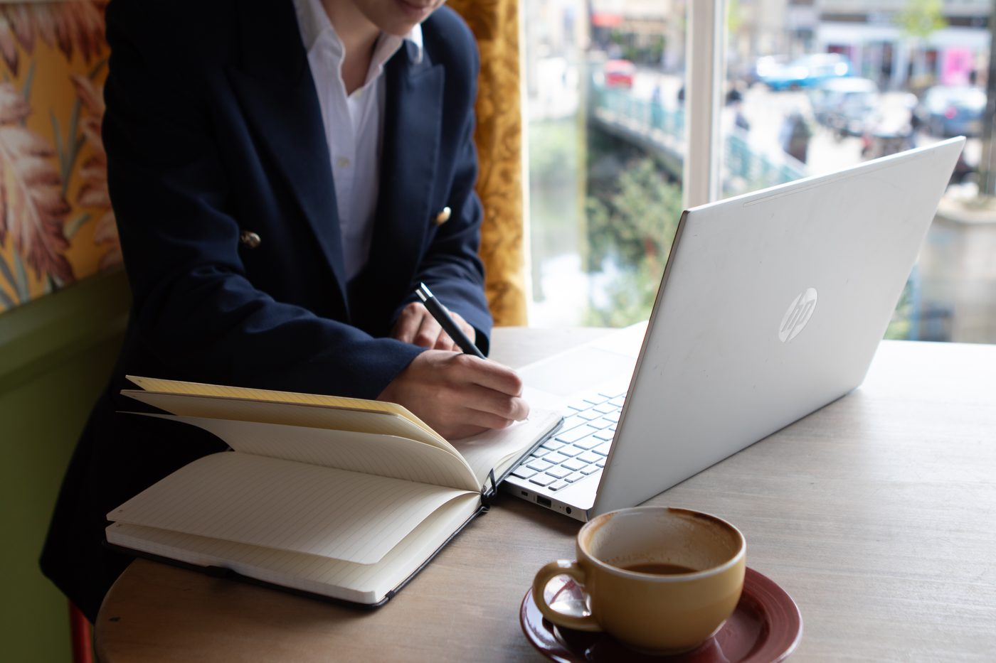 Notes being written during an online coaching session, laptop open beside a notebook